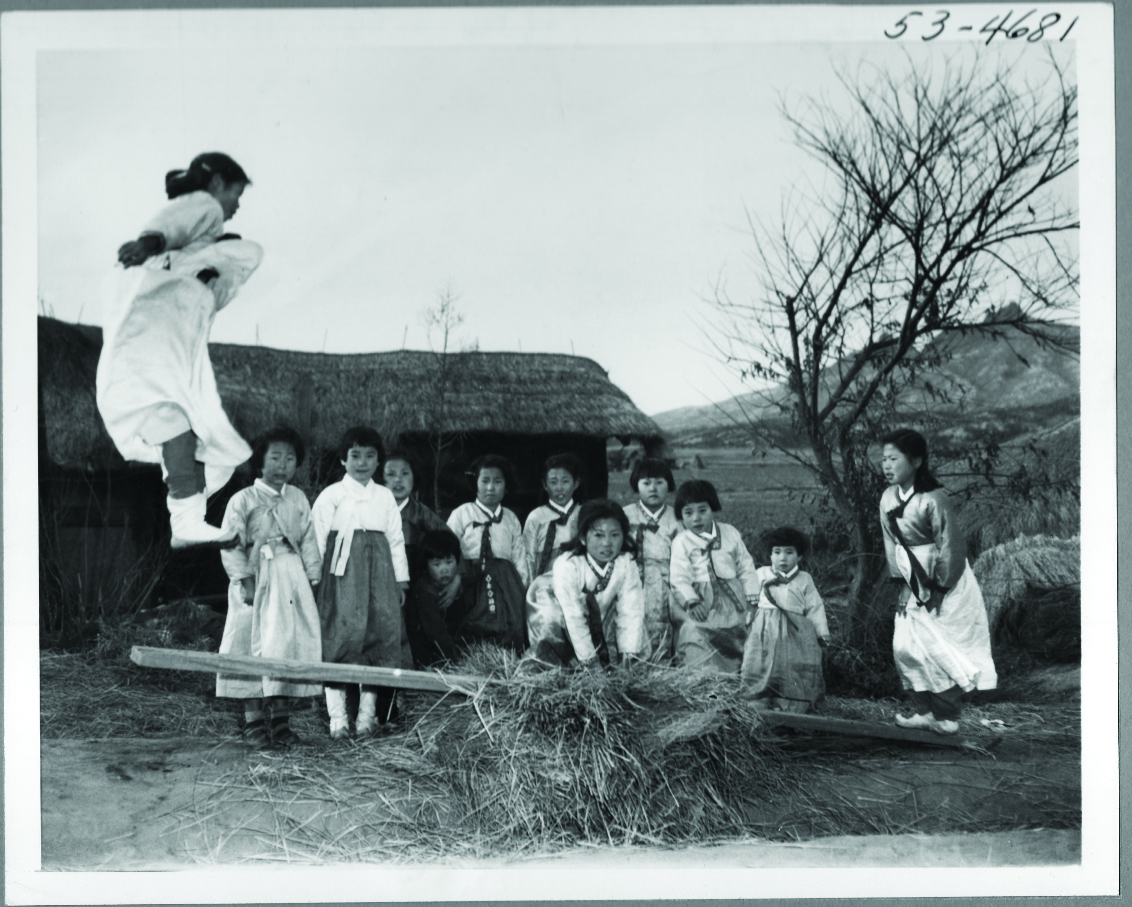 1953.2.19. 전쟁 중이지만 설빔을 차려입은 천진난만한 소녀들이 널뛰기를 하고 있다.